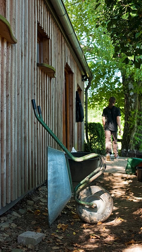 Trillebår ved et skur.